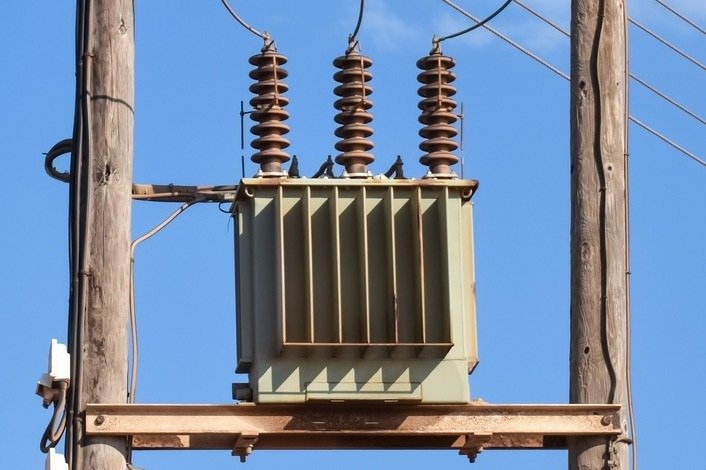 Transformador de média tensão em poste de madeira, parte de projetos elétricos.
